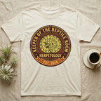 Cream t-shirt with circular "Keeper of the Reptile Room Herpetology Est. 2018" logo.