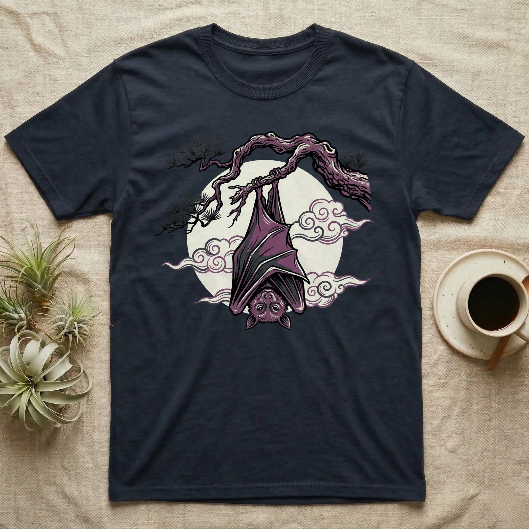Dark t-shirt featuring a purple bat hanging upside down from a tree branch.