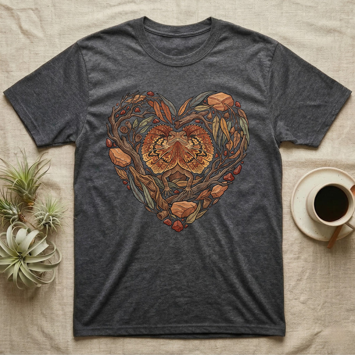 Dark grey t-shirt featuring a heart-shaped design of a frilled lizard and natural elements.