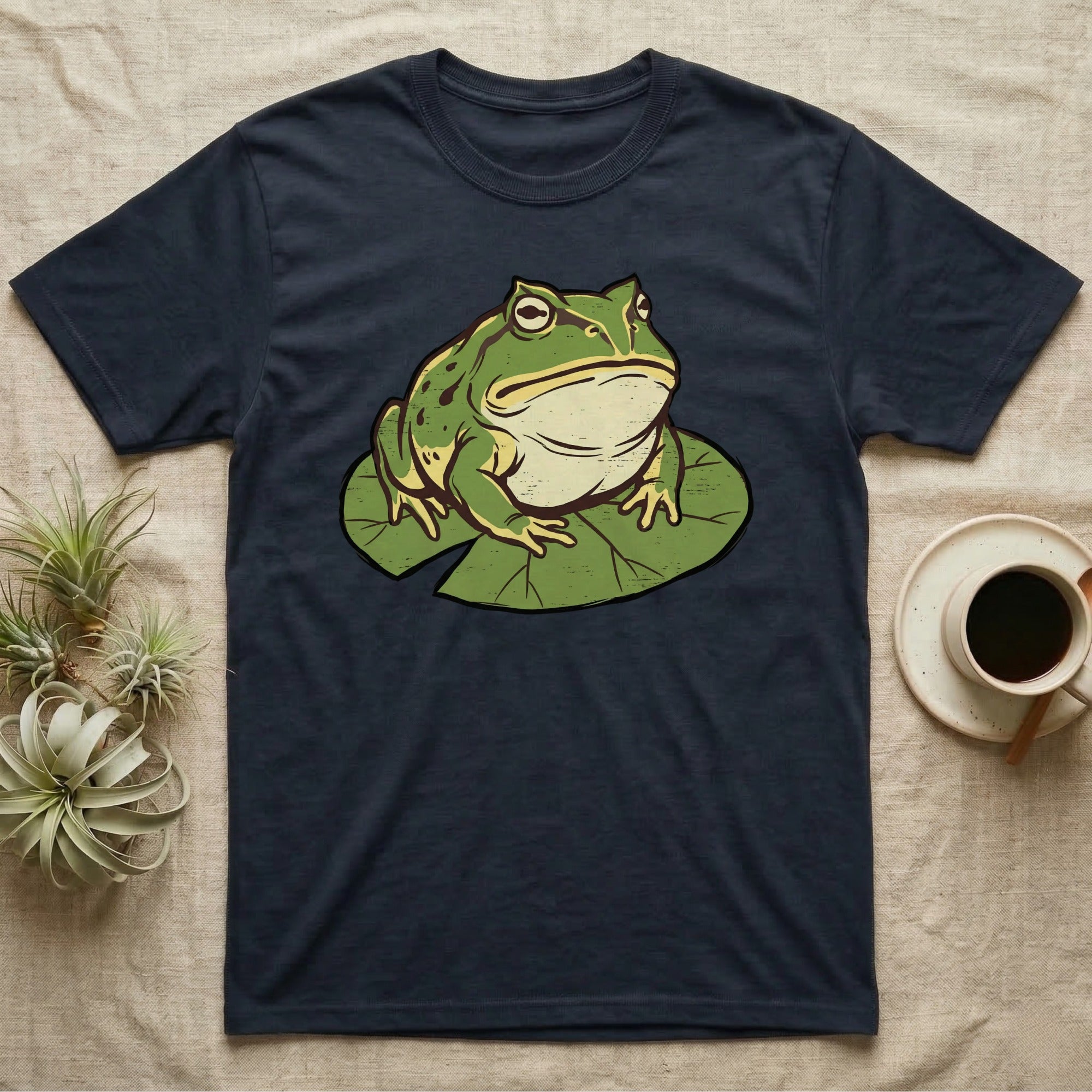 Dark navy t-shirt with a graphic of a green frog on a lily pad.