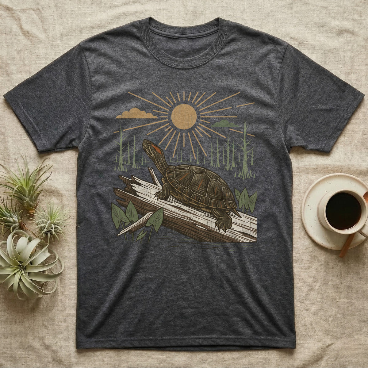 Red-Eared Slider Home Range T-Shirt in Dark Heather — Woodcut-style illustration of a red-eared slider basking on a half-sunk log in a cypress swamp under a full sun, no on-shirt text.