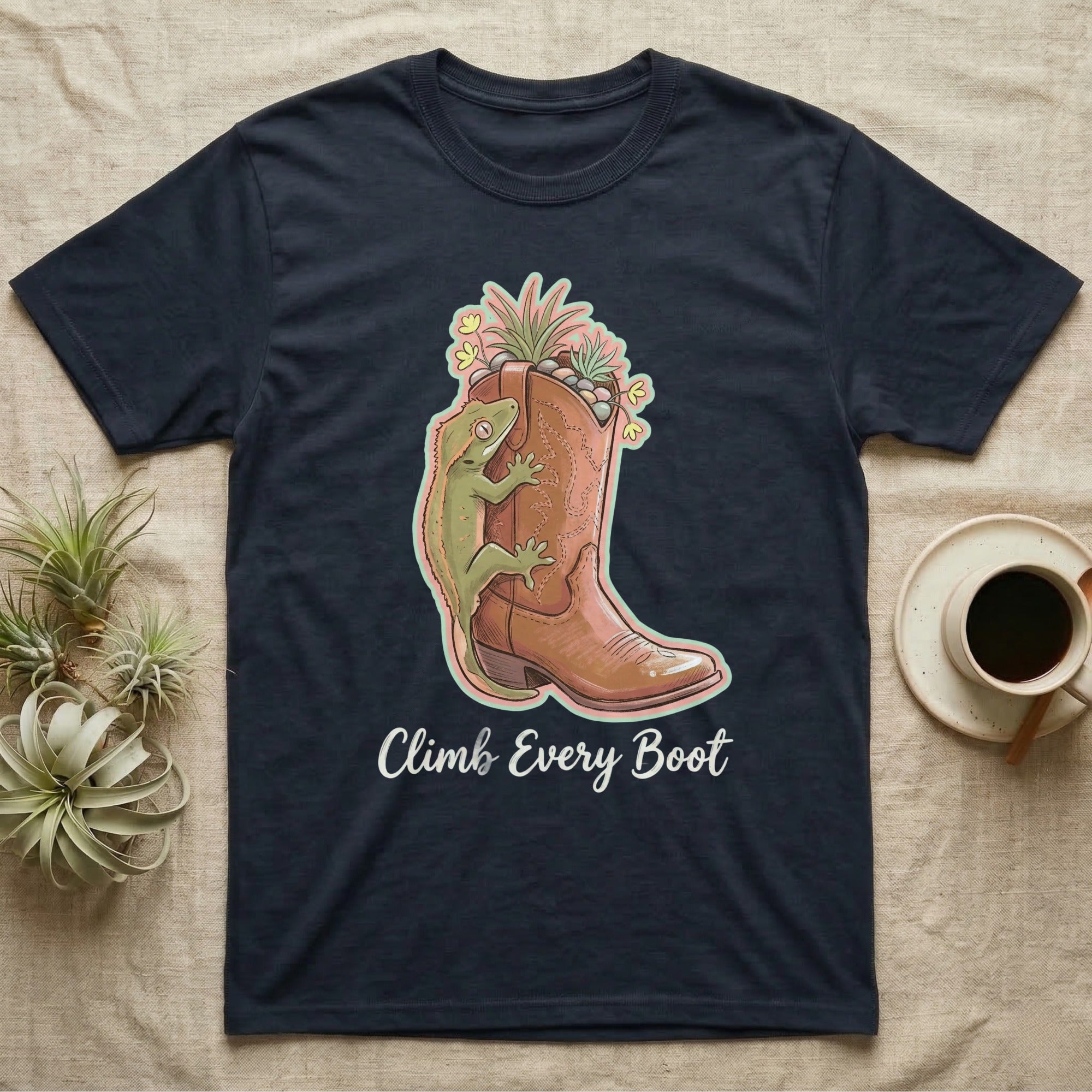 Dark t-shirt with graphic of a gecko on a cowboy boot, surrounded by plants.
