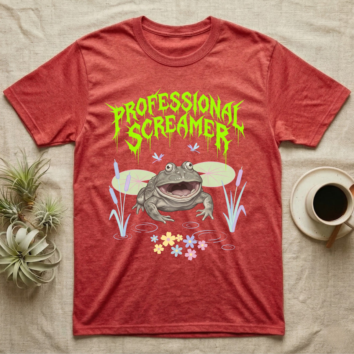 Budgett's Frog Feral T-Shirt in Heather Red — Budgett's frog with wide screaming mouth under jagged acid-green metal text PROFESSIONAL SCREAMER with lily pads