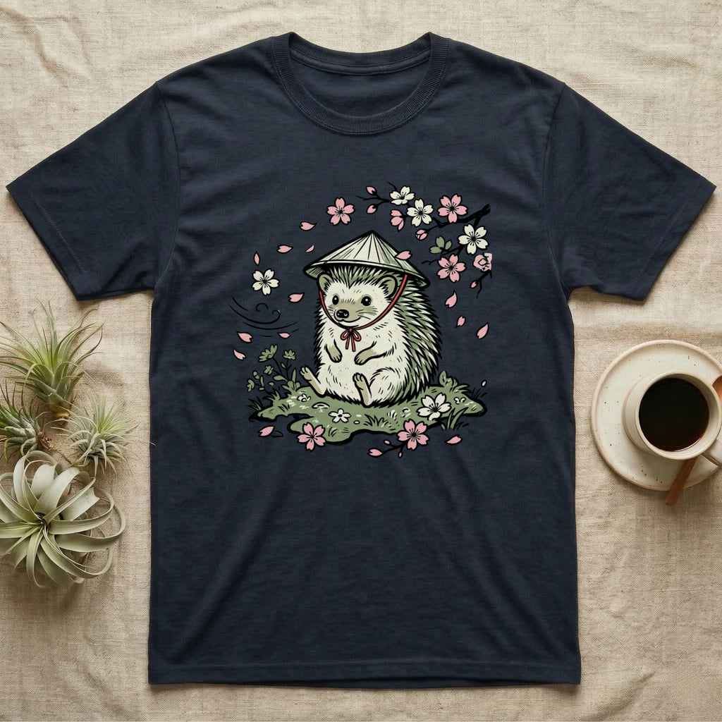 Hedgehog wearing a straw hat sitting among cherry blossoms and pink flowers.