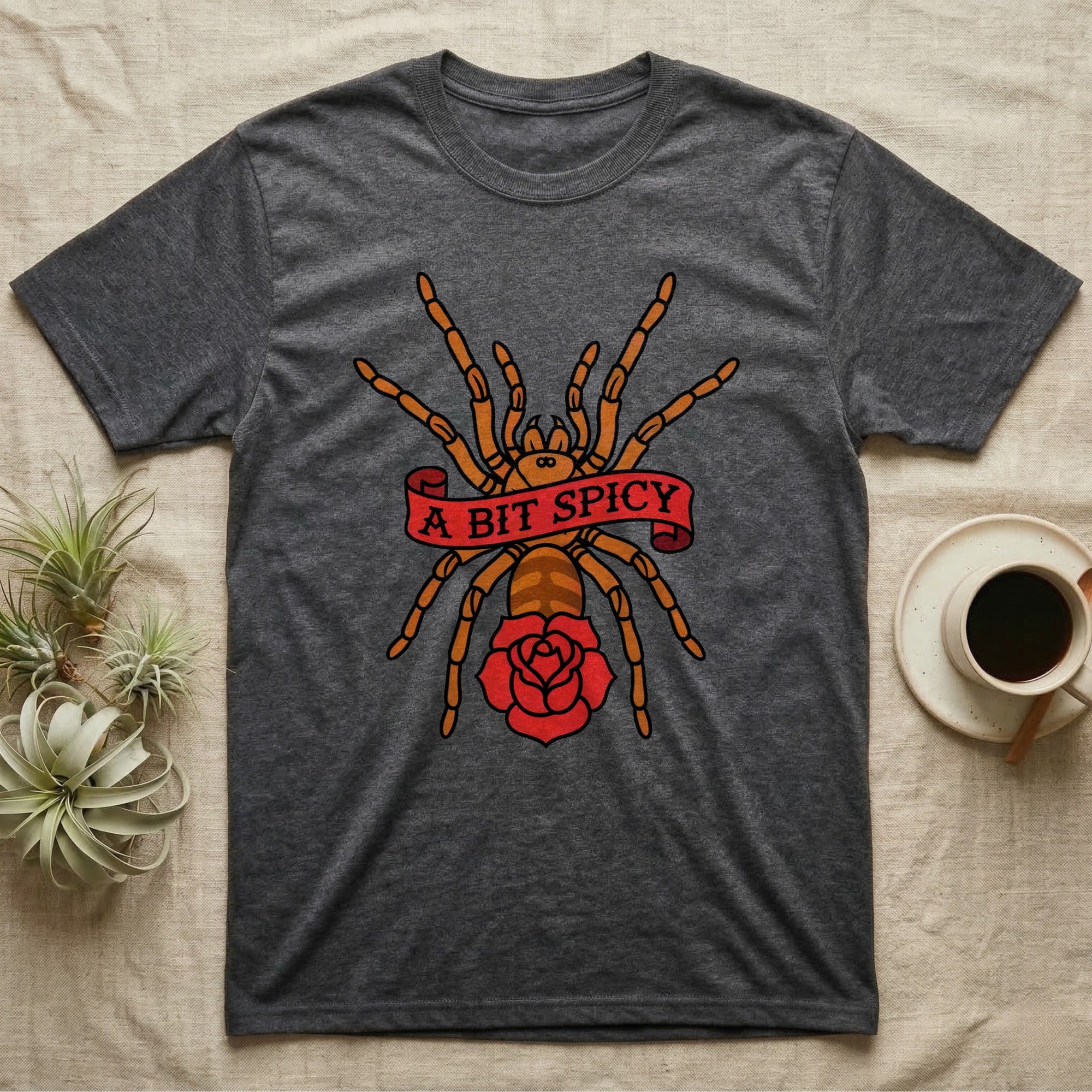 Tarantula A Bit Spicy T-Shirt in Dark Heather — Tattoo-flash orange-baboon-tarantula in threat-pose with banner-scroll "A Bit Spicy" and a flash rose beneath.