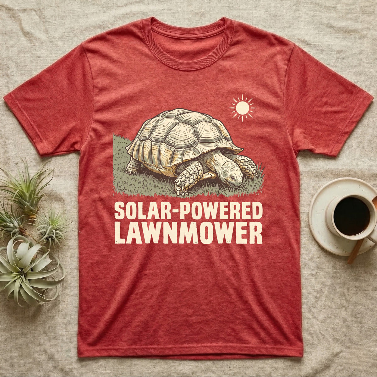 Solar Powered Lawnmower T-Shirt in Heather Red — Retro-illustration of a sulcata tortoise grazing a lawn stripe under a sun motif with a Solar-Powered Lawnmower caption.