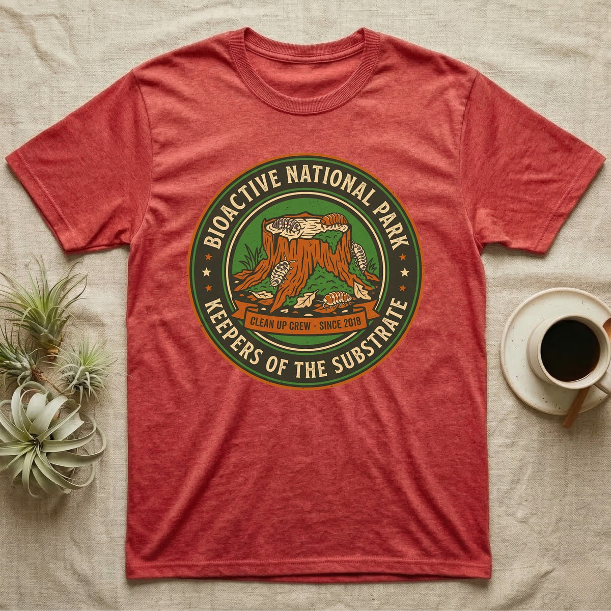 Isopod Keepers of the Substrate T-Shirt in Heather Red — Weathered green park badge with isopods working a mossy stump and leaf litter, cream arc lettering.