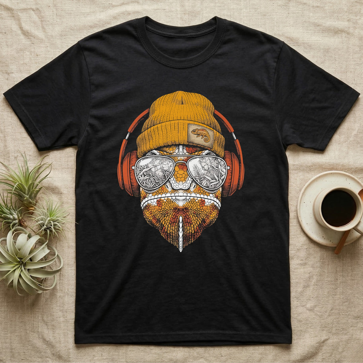 Chameleon Chill Vibes T-Shirt in Black — Engraved chameleon with patterned orange skin in a beanie and headphones, aviators reflecting a jungle canopy.