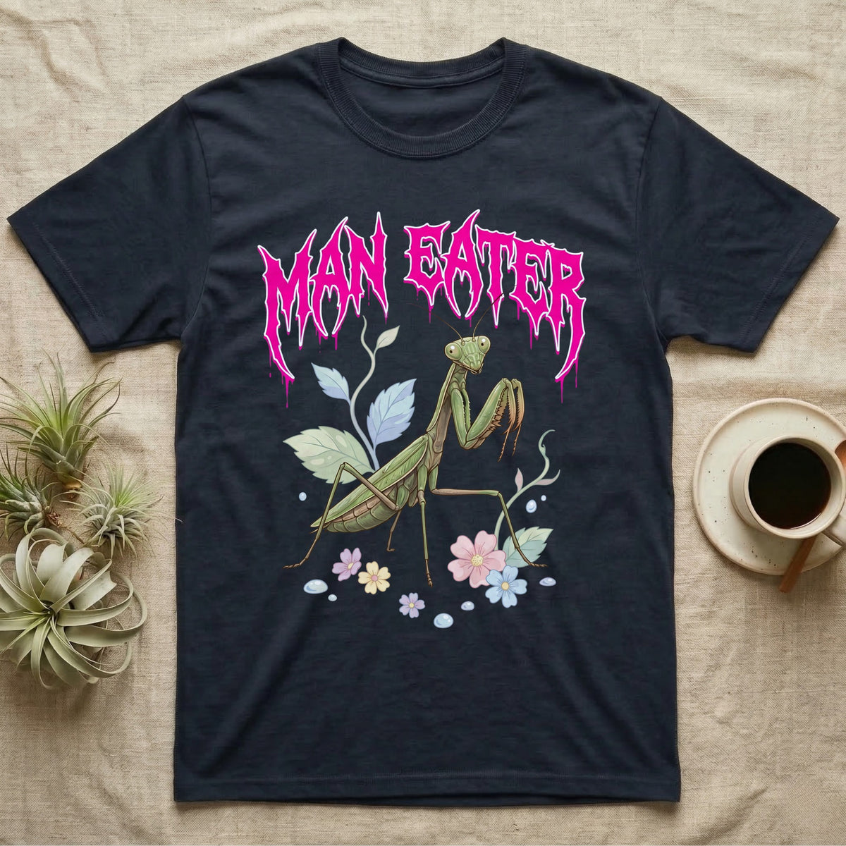 Chinese Mantis Feral T-Shirt in Navy — Pastel Chinese mantis with raised spiked forelegs among leaves and blossoms, jagged magenta metal wordmark "MAN EATER" above.