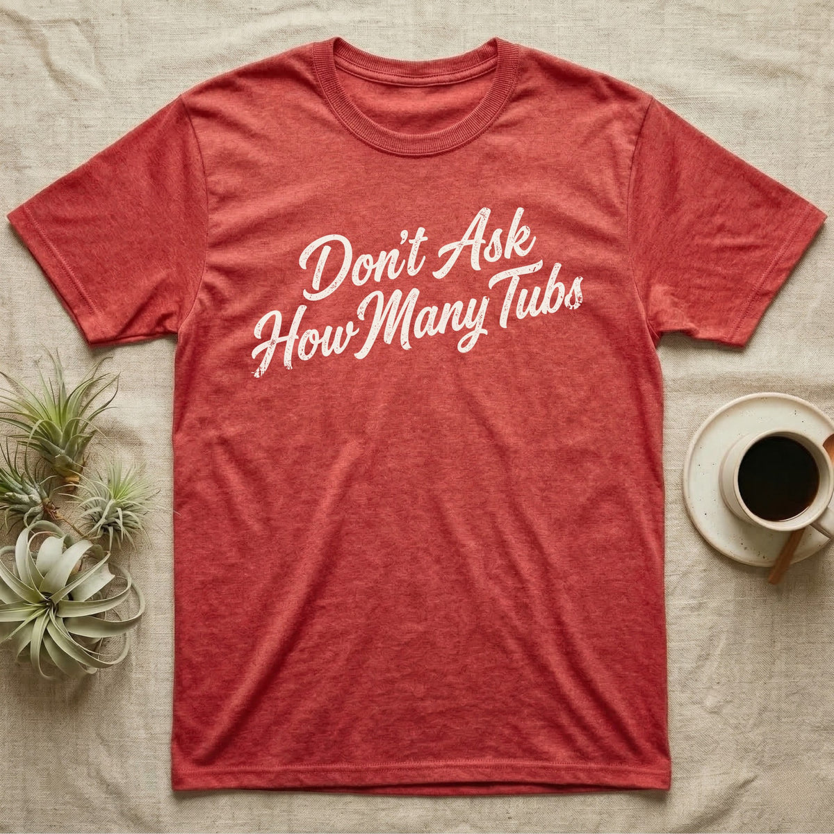 Snake Tubs T-Shirt in Heather Red — Worn off-white 1970s retro brush script climbing a diagonal on charcoal, reading Don't Ask How Many Tubs