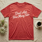 Snake Tubs T-Shirt in Heather Red — Worn off-white 1970s retro brush script climbing a diagonal on charcoal, reading Don't Ask How Many Tubs