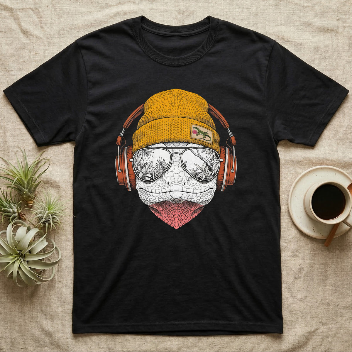 Green Anole Chill Beats T-Shirt in Black — Engraved green anole with pink dewlap showing, in a beanie and headphones, aviators reflecting tropical palms.