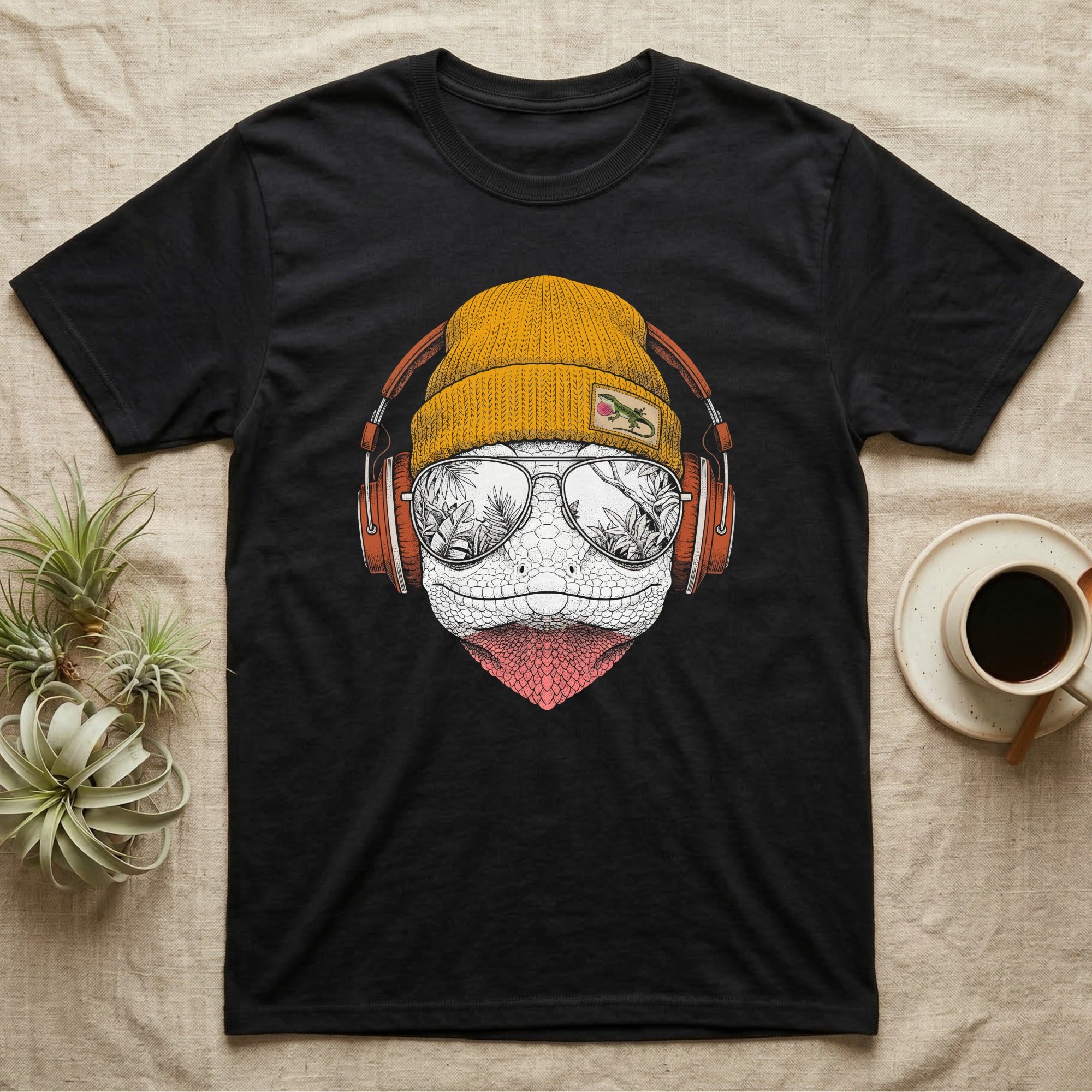 Green Anole Chill Beats T-Shirt in Black — Engraved green anole with pink dewlap showing, in a beanie and headphones, aviators reflecting tropical palms.
