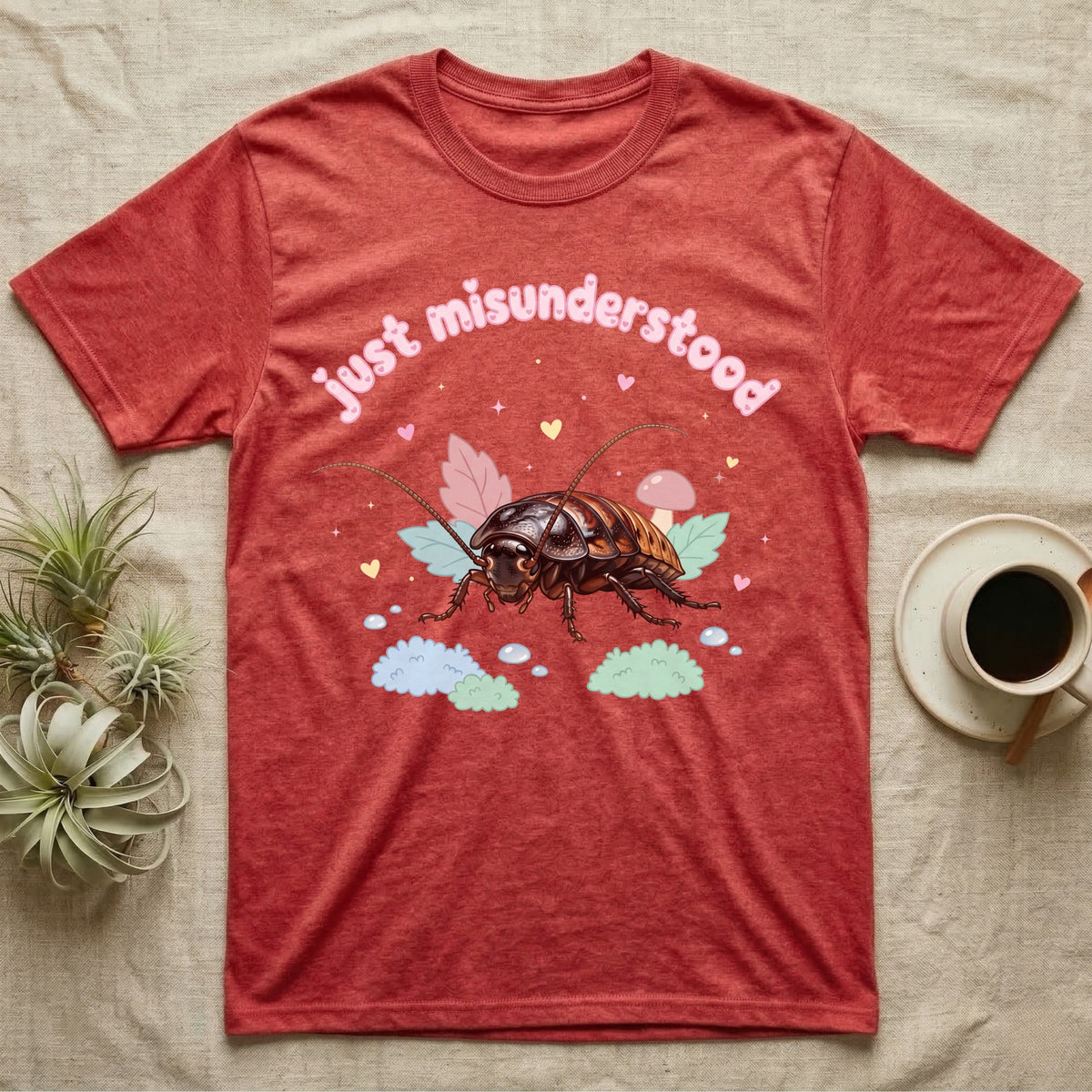 Madagascar Hissing Cockroach Baby T-Shirt in Heather Red — Pastel Madagascar hissing cockroach among leaves, mushroom and moss, puffy pink wordmark "just misunderstood" above.