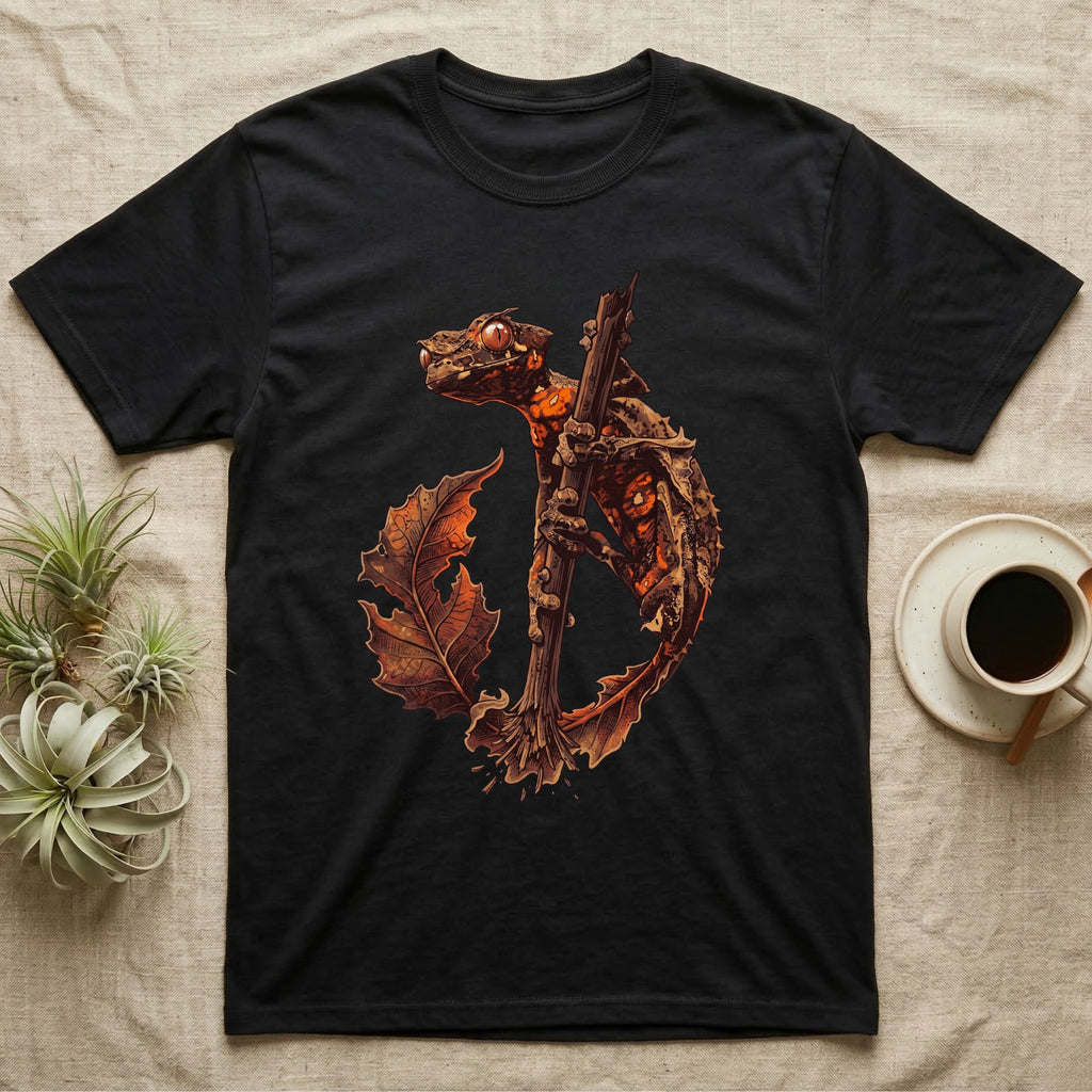 Vintage ink illustration of an eyelash leaf-tailed gecko clinging to a branch with its tail curled beside a serrated leaf, no on-shirt text. — shown on a Black tee.