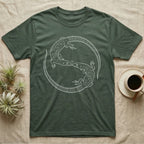 Ackie Monitor Roundel T-Shirt in Military Green — Two ackie monitors in fine white line art, mirrored at 180 degrees around a tiny heart, tails sweeping outward.