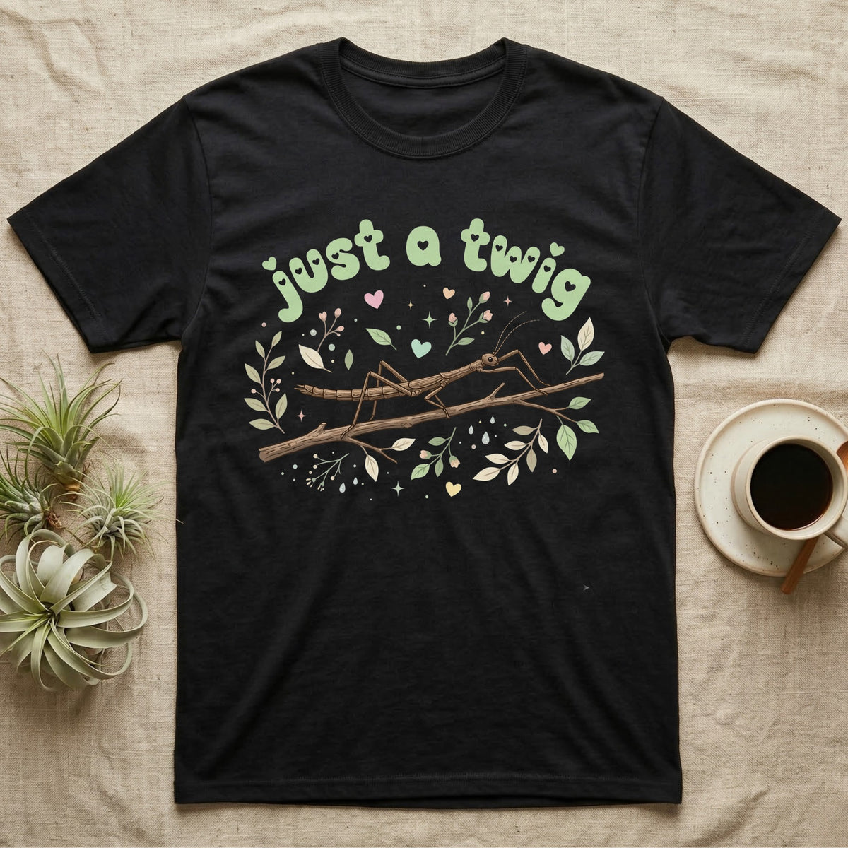 Stick Insect Softie T-Shirt in Black — Camouflaged stick insect on a branch under pastel bubble text "just a twig" with tiny hearts.