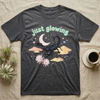 Emperor Scorpion Baby T-Shirt in Dark Heather — Black emperor scorpion, pincers raised, under a pastel moon and stars with puffy mint bubble text "just glowing".
