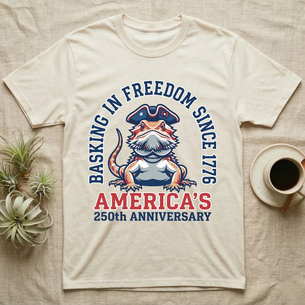 Bearded Dragon Basking T-Shirt in Natural — Sports-logo bearded dragon in a tricorn hat under a collegiate arch reading Basking in Freedom Since 1776.