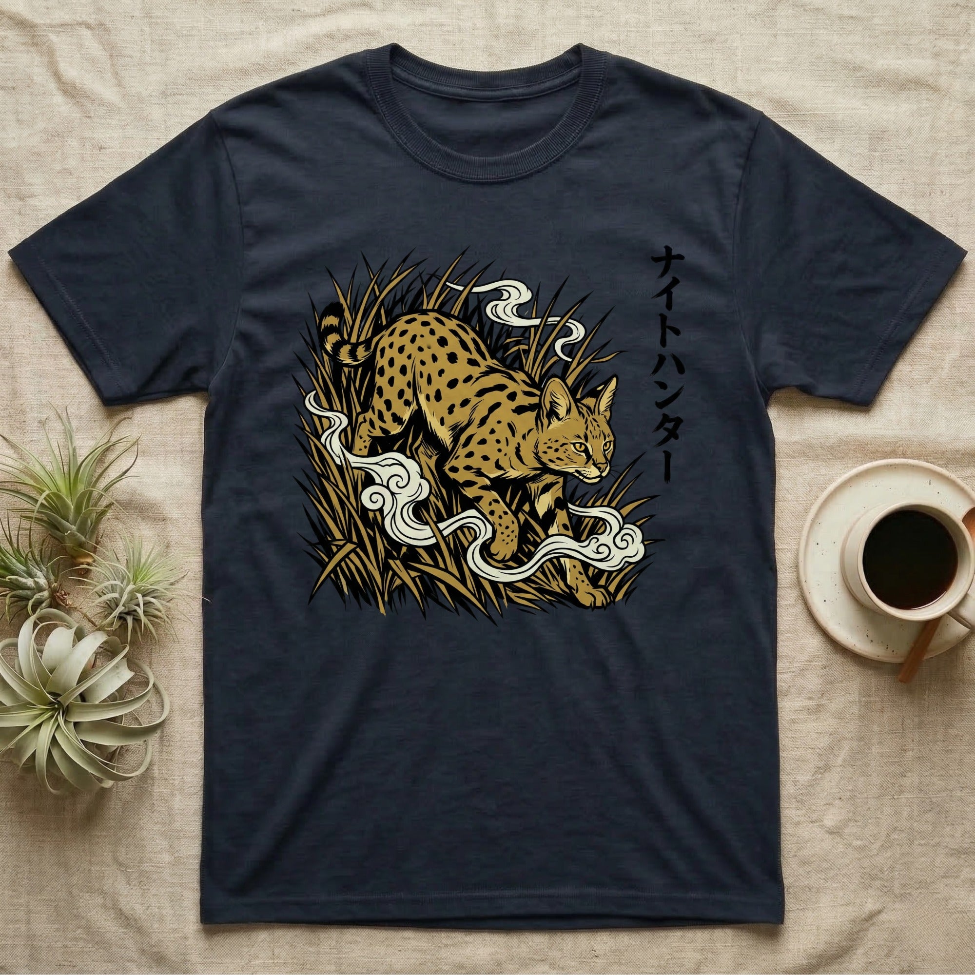 Dark t-shirt with spotted cat and Japanese text in tall grass.