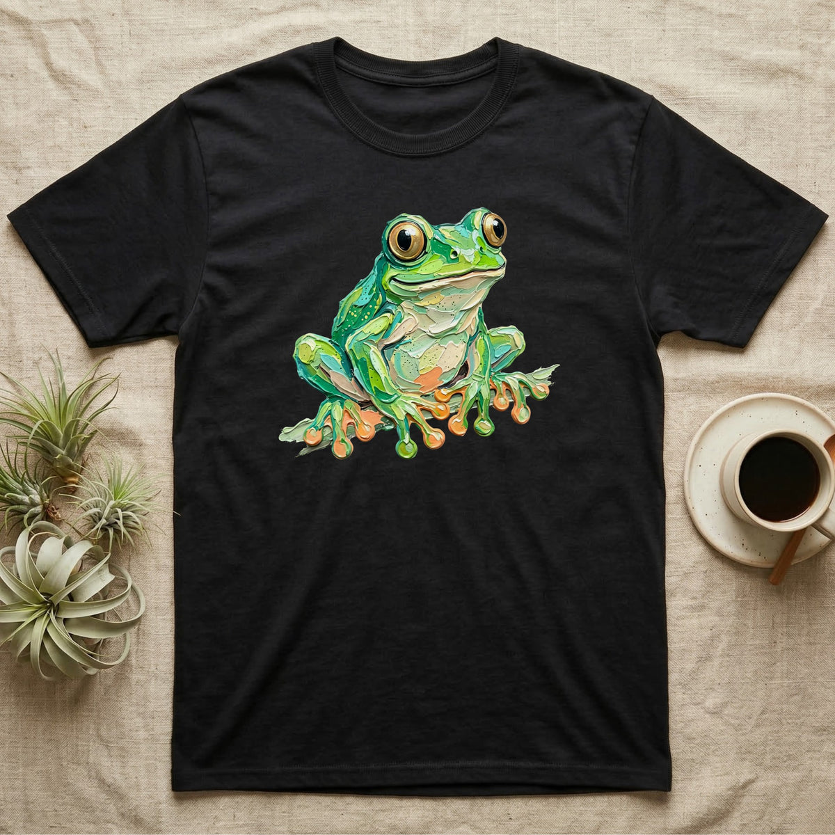 Black t-shirt featuring a vibrant, cartoonish green frog illustration.