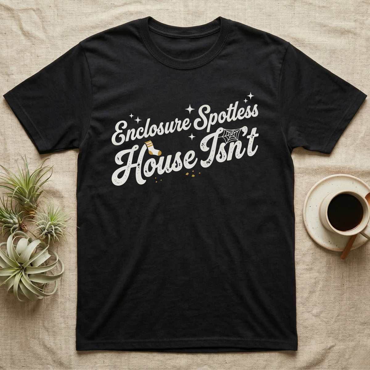 Terrarium Spotless House T-Shirt in Black — Retro script reading Enclosure Spotless with sparkles above grubby lettering reading House Isn't with a sock, cobweb and crumbs