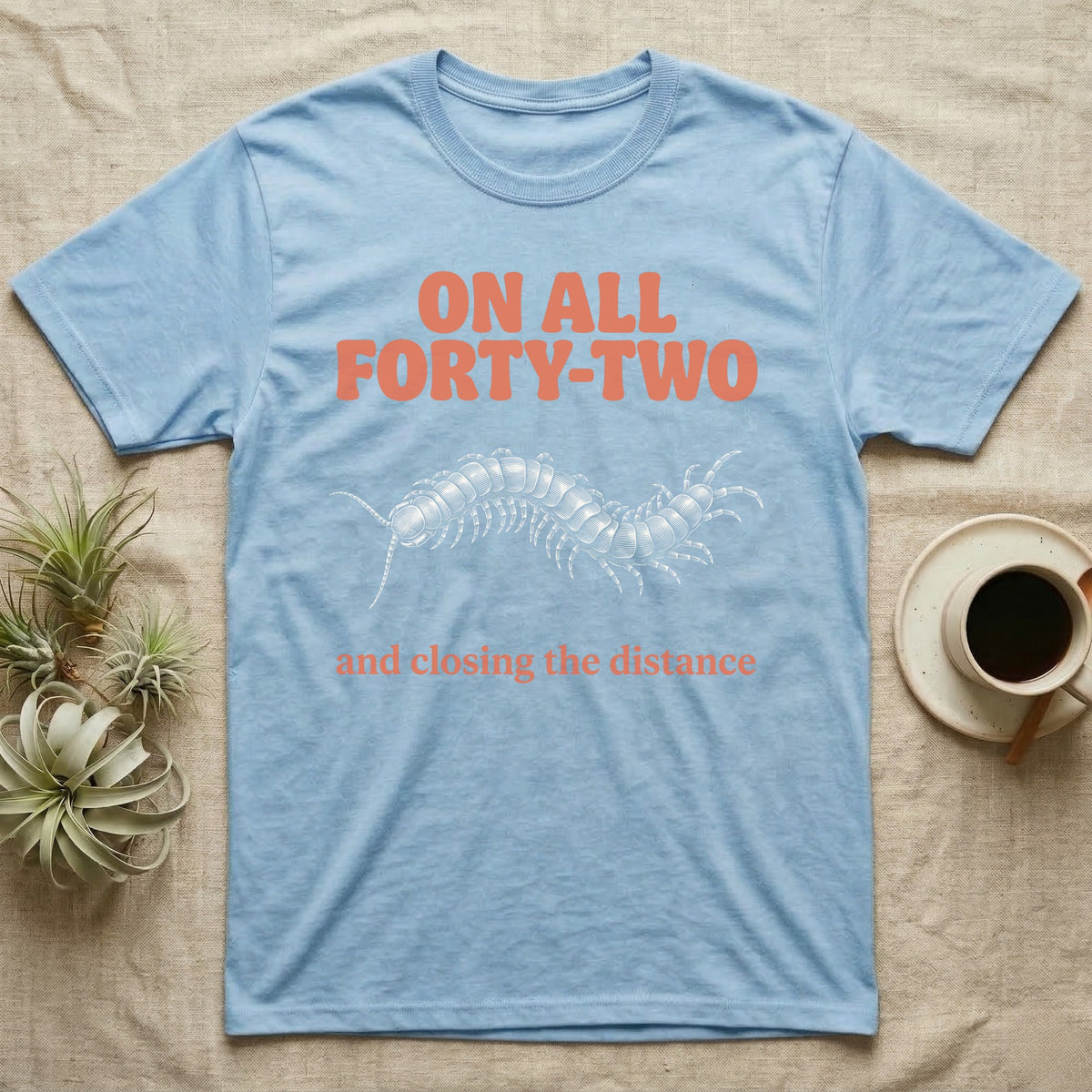Light blue t-shirt with orange text "ON ALL FORTY-TWO" and centipede graphic.
