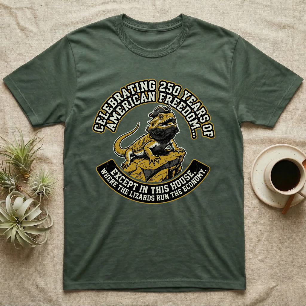Bearded Dragon 1776 T-Shirt in Military Green — Bold woodcut tee of a bearded dragon in a tricorn hat black-bearding on a rock, gold and cream banner reading the lizards run the economy.