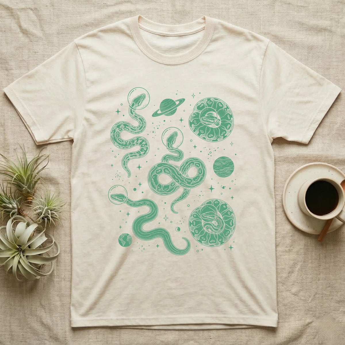 Ball Python Cosmic T-Shirt in Natural — Vintage screen-print illustration of ball pythons in astronaut helmets floating in space, deep emerald green monochromatic on dark background.