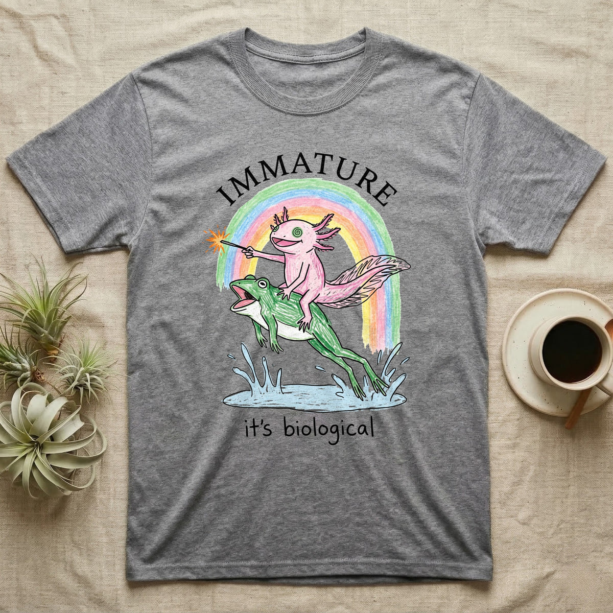 Axolotl Immature T-Shirt in Sport Grey — Crayon drawing of a pink axolotl riding a leaping green frog through a rainbow, sparkler lit, under IMMATURE