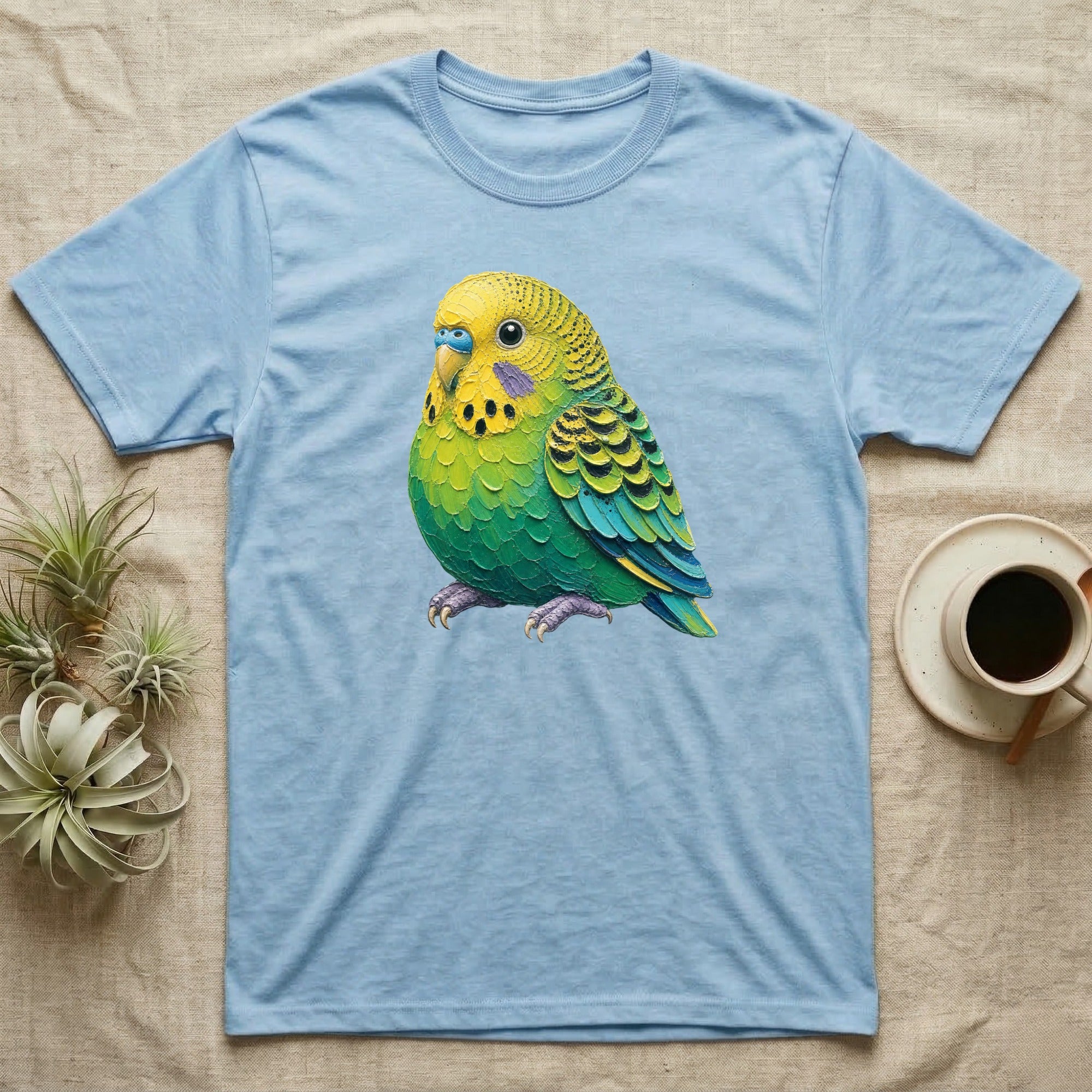 Light blue t-shirt with a colorful green and yellow budgie bird graphic.