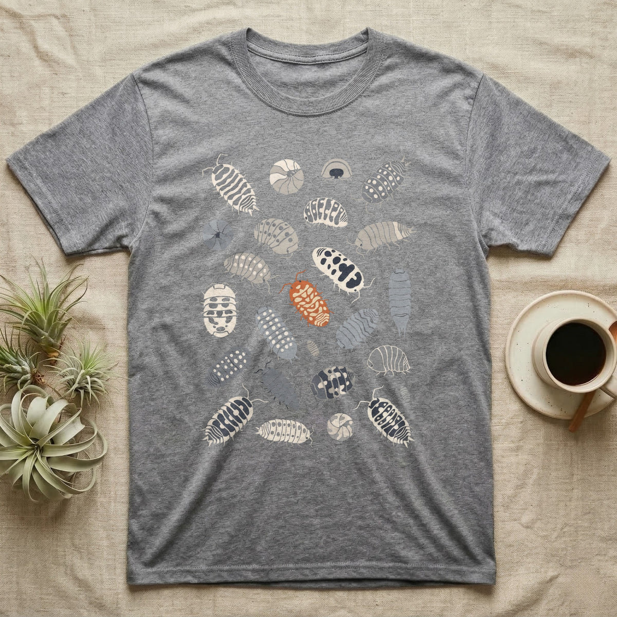 Isopod Morph Plate T-Shirt in Sport Grey — About twenty-five flat-painted isopods scattered across grey, all shapes and patterns, one of them orange.