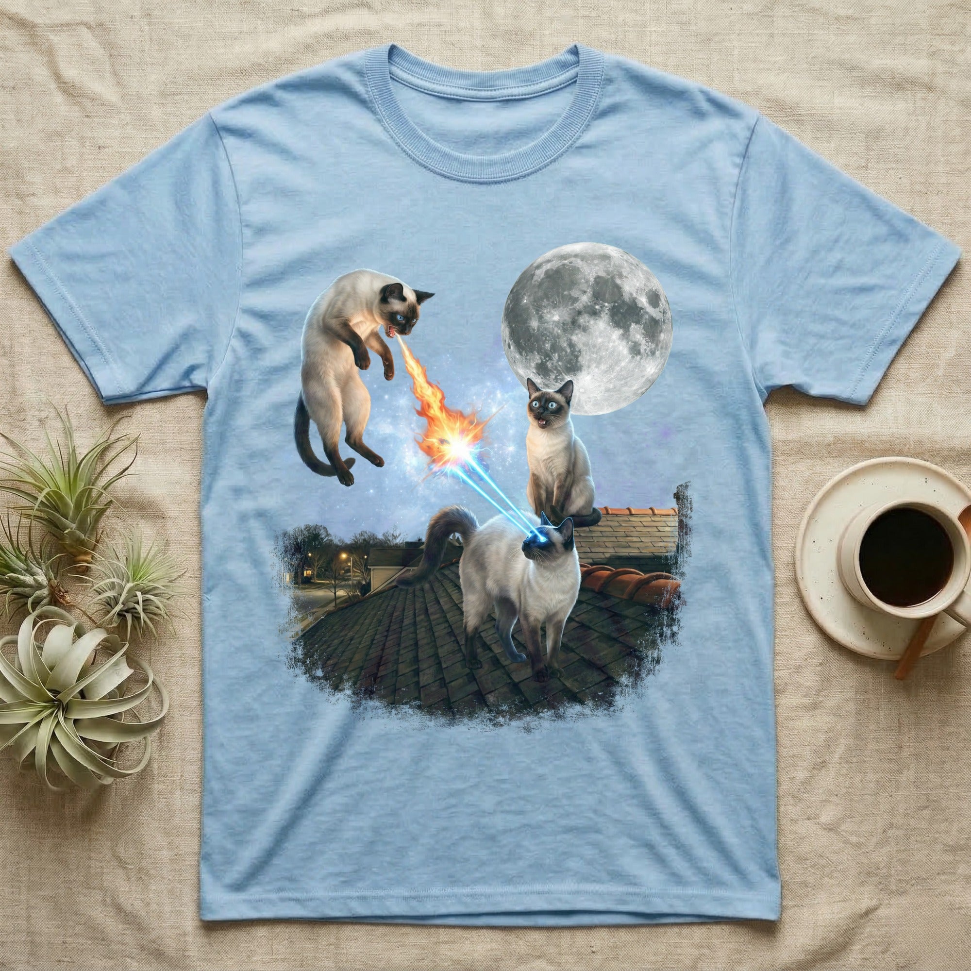 Light blue t-shirt with three siamese cats on a rooftop with laser eyes and a moon.