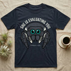 Phidippus Regius Jumping Spider Tee in Navy — Vector-bold front-facing regal jumping spider portrait with electric-teal anterior-median eyes on a cream-and-charcoal body.