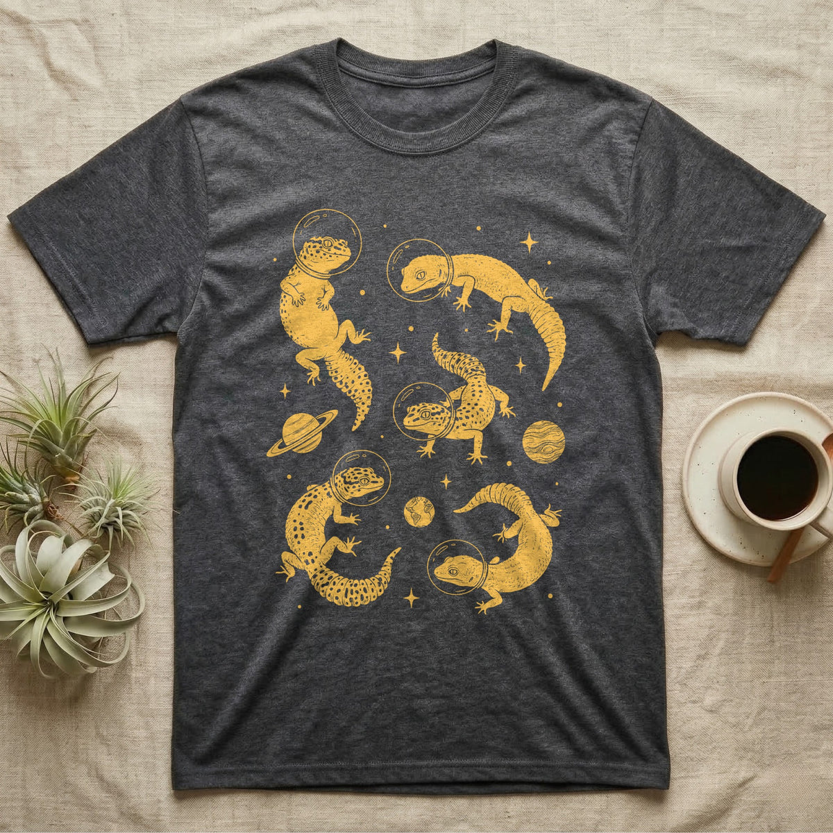 Leopard Gecko Cosmic T-Shirt in Dark Heather — Vintage screen-print illustration of leopard geckos in astronaut helmets floating in space, sulfur amber monochromatic on dark background.
