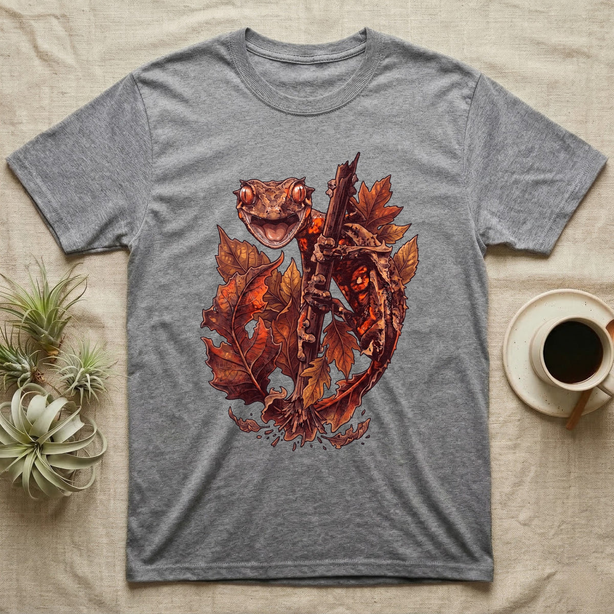 Satanic Leaf-Tailed Gecko Autumn T-Shirt in Sport Grey — Painted illustration of a satanic leaf-tailed gecko gripping a bare stem among dried autumn leaves in rust and amber, no on-shirt text.