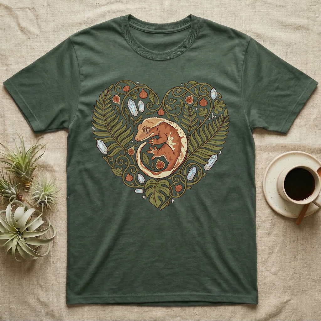 Crested gecko nestled in a heart-shaped botanical design on a green t-shirt.