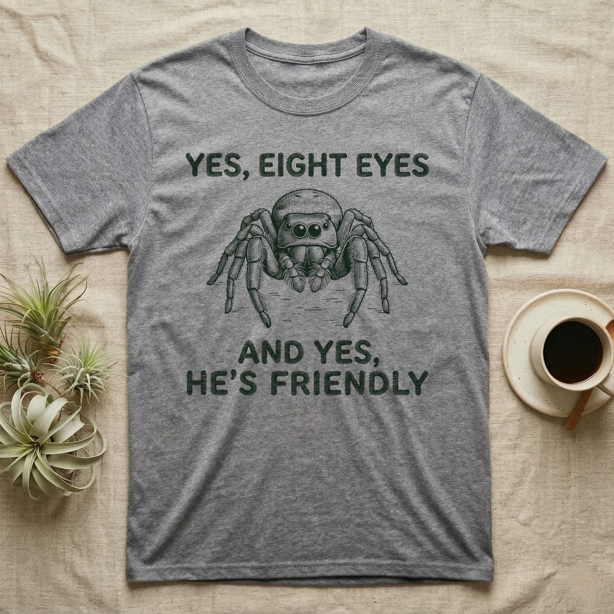Jumping Spider Eight Eyes T-Shirt in Sport Grey — Engraved jumping spider head-on with large forward eyes, between stitch-look lettering on grey.