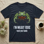 Deadpan mugshot of an olive-green fire-bellied toad on black, captioned I'm mildly toxic, wash your hands. — shown on a Navy tee.