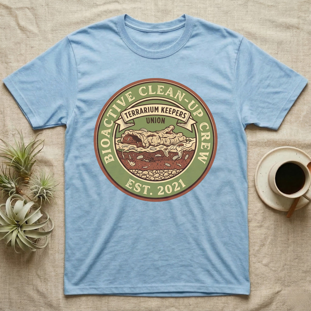 Isopod Terrarium Keepers Union T-Shirt in Light Blue — Vintage union badge showing a cross-sectioned bioactive vivarium worked by isopods and springtails.