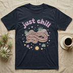Rosy Boa Softie T-Shirt in Navy — Relaxed coiled rosy boa with sleepy eyes under pastel bubble text "just chill" with tiny hearts.