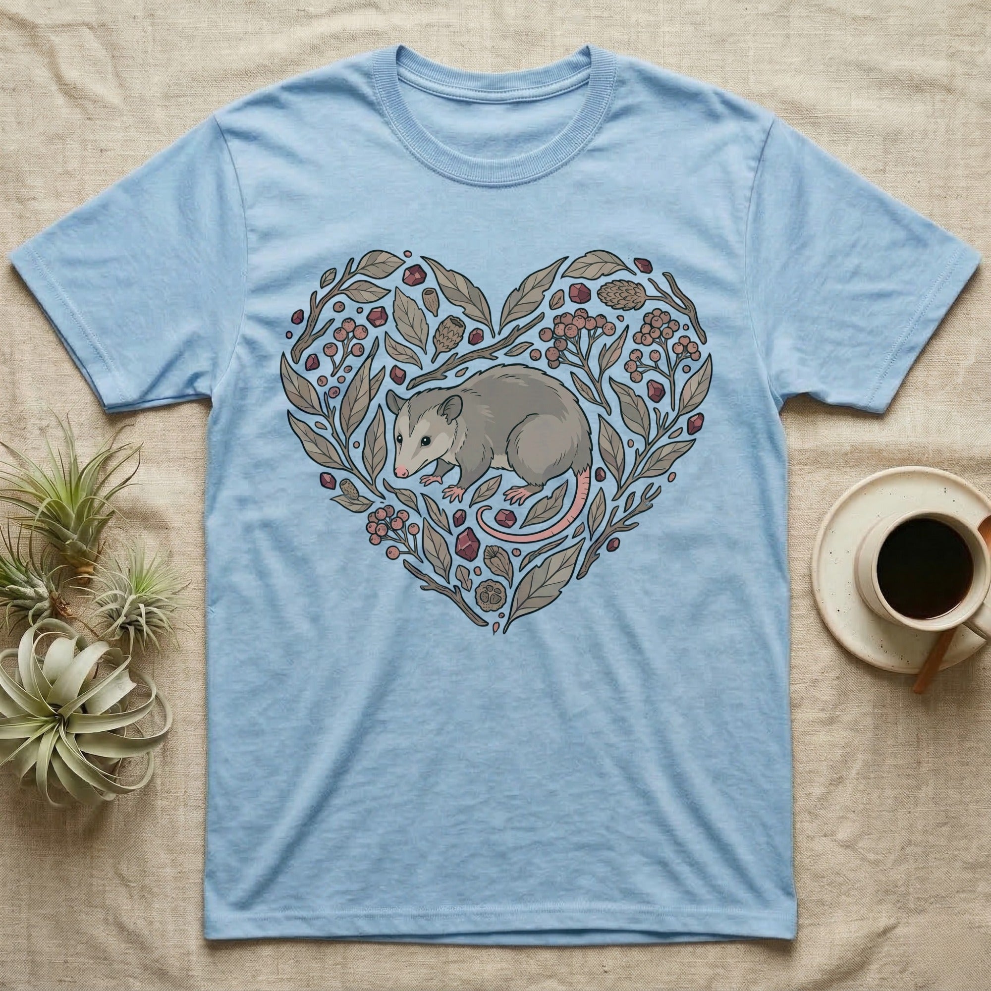 Light blue t-shirt with a heart-shaped nature design featuring a possum.