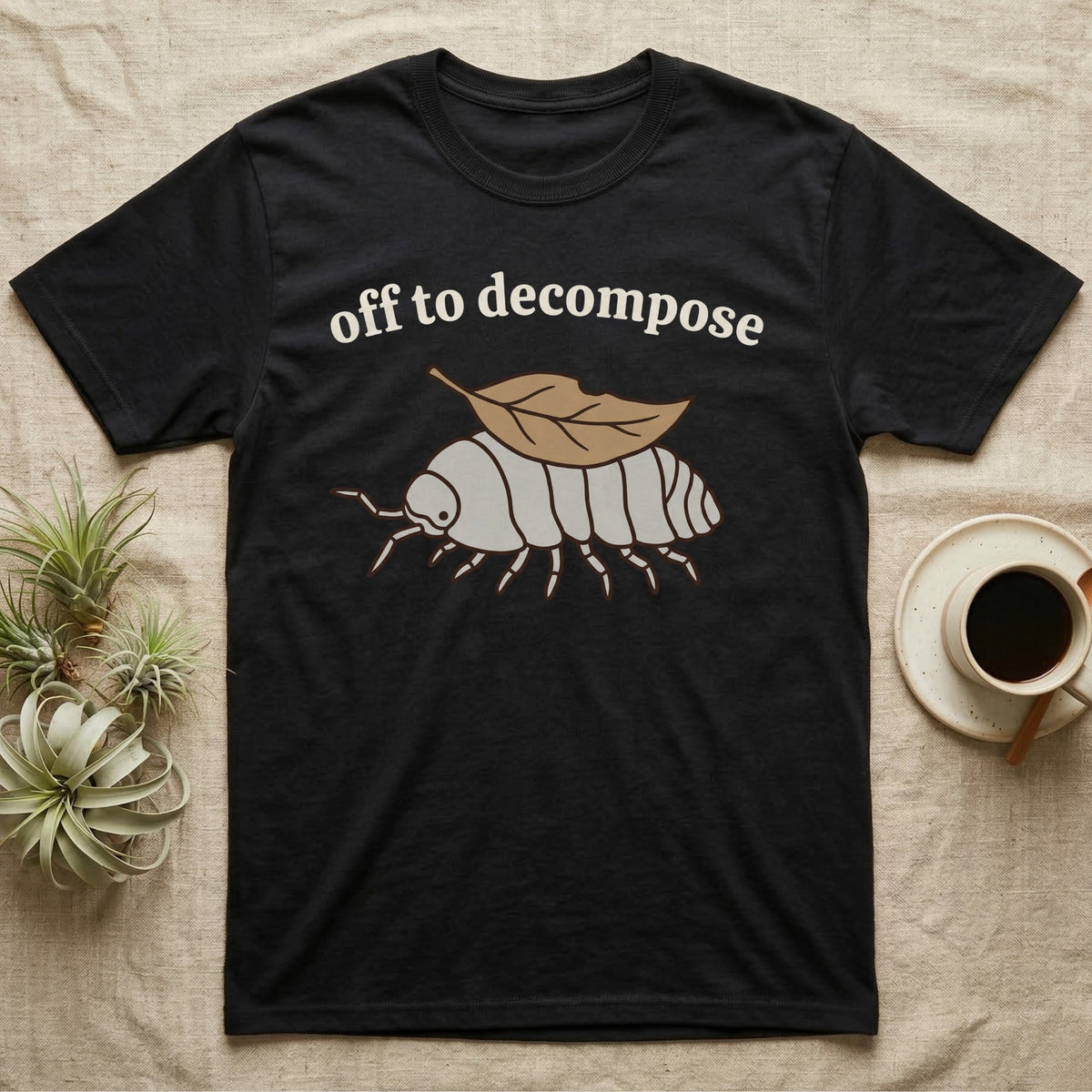 Isopod Decomposer T-Shirt in Black — Minimal doodle of a grey isopod walking off with a dead leaf on its back under the words off to decompose