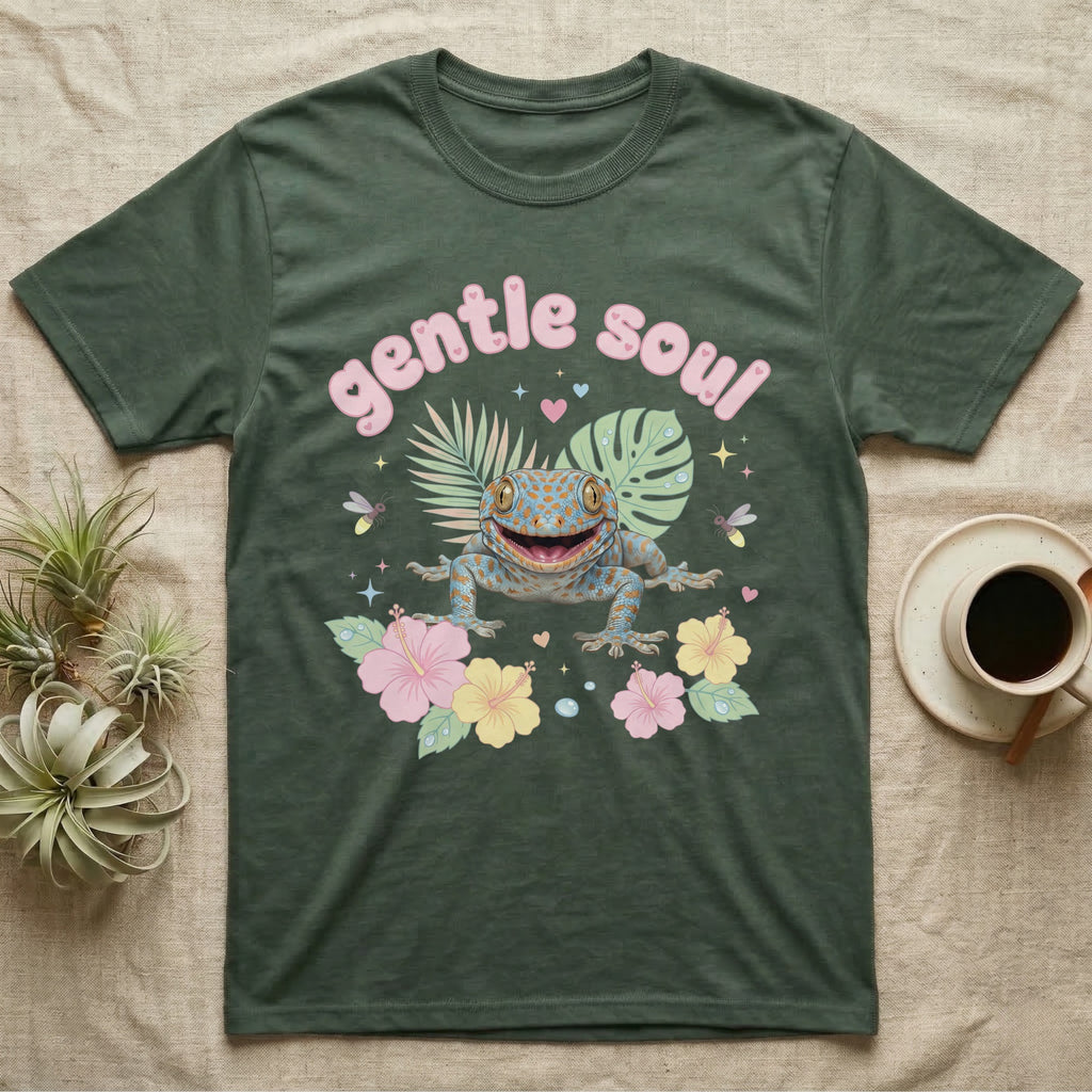 Tokay Gecko Baby T-Shirt in Military Green — Blue-and-orange spotted tokay gecko among pastel leaves and hibiscus under puffy pink bubble text "gentle soul".
