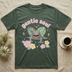 Tokay Gecko Baby T-Shirt in Military Green — Blue-and-orange spotted tokay gecko among pastel leaves and hibiscus under puffy pink bubble text "gentle soul".