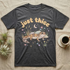 African Fat-Tailed Gecko Softie T-Shirt in Dark Heather — African fat-tailed gecko with a plump tail under a puffy pastel "just thicc" bubble wordmark with tiny hearts.