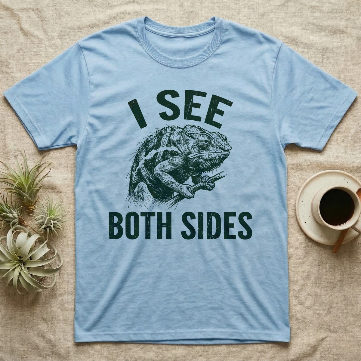 Panther Chameleon Mediator T-Shirt in Light Blue — Etching of a panther chameleon holding a twig, its eyes pointing opposite ways, under I SEE, above BOTH SIDES