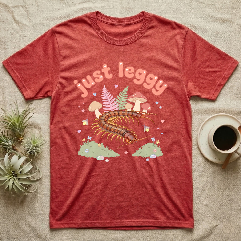 Vietnamese Centipede Baby T-Shirt in Heather Red — Many-legged Vietnamese centipede curving among pastel ferns and toadstools under puffy coral text "just leggy".