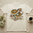Hognose Hunger Flash T-Shirt in Natural — American-traditional tattoo-flash illustration of a hognose snake in a heroic coil with a banner reading the feeding-hunger line.