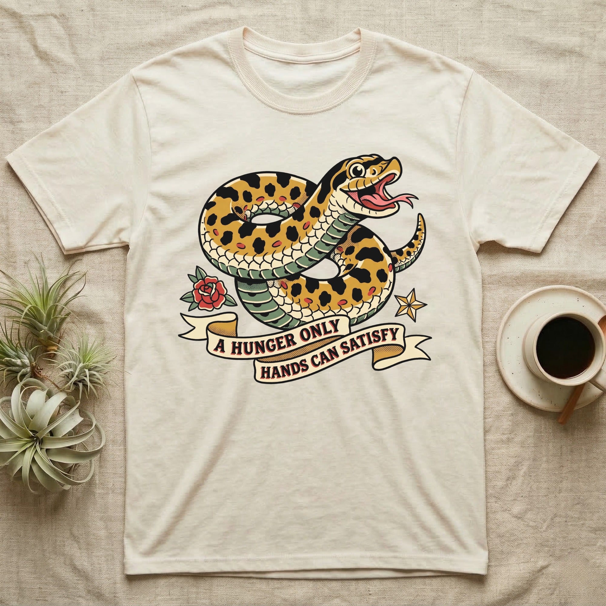 Hognose Hunger Flash T-Shirt in Natural — American-traditional tattoo-flash illustration of a hognose snake in a heroic coil with a banner reading the feeding-hunger line.